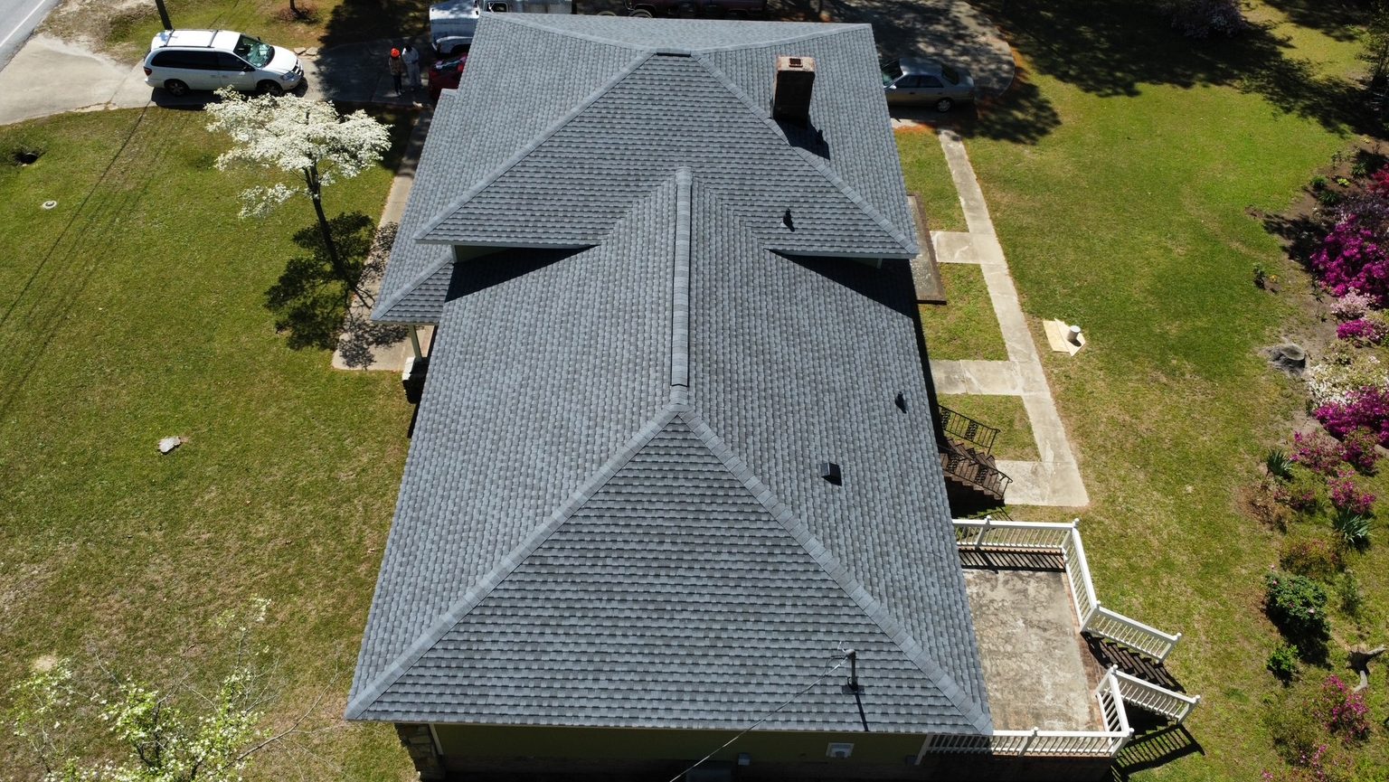 Overhead drone shot of a finished hip roof with new ridge caps
